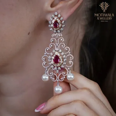 The pinnacle of glamour. These chandelier earrings feature a breathtaking design of rubies, diamonds, and pearls, crafted to create a statement of pure luxury and intricate artistry.