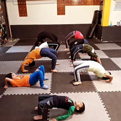 Our junior squad working on their bridge poses. We teach them proper form from a young age to build a strong foundation for any sport they choose.
