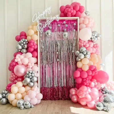 A fabulous photo backdrop made with a shimmering silver curtain and a lush arch of pink and silver balloons, complete with disco balls. The 'Happy Birthday' neon sign adds the final touch.