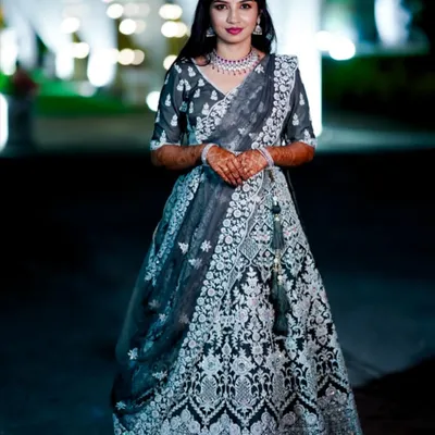 A full-length view of this stunning reception look. The makeup was designed to be elegant and photogenic, with a bold lip and defined eyes that stand out beautifully against the intricate silver embroidery of her lehenga.