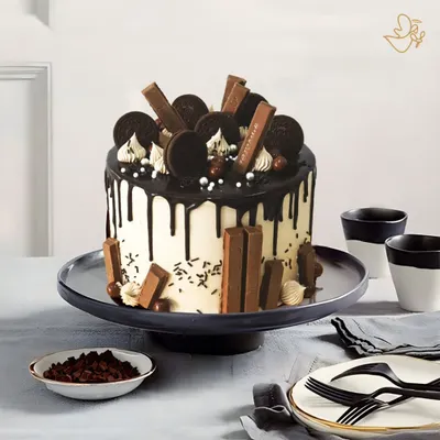 A true chocolate lover's paradise. This cake is loaded with KitKats, Oreos, and chocolate balls, all brought together with a rich, dark chocolate drip over a smooth buttercream finish.