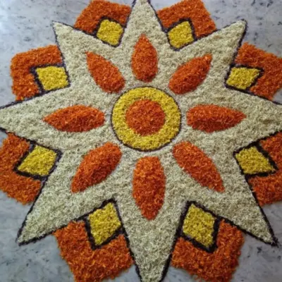 A star-shaped floral rangoli, or 'pookalam', made entirely from fresh flower petals. This kind of detailed work is perfect for welcoming guests at the entrance.