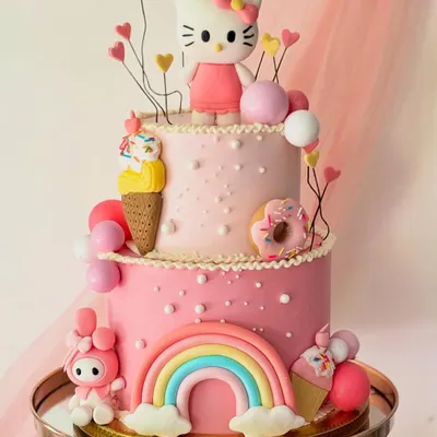 A two-tiered dream for a Hello Kitty fan, this cake is loaded with fun details. It features a Hello Kitty topper, a rainbow, donuts, and ice cream cones, all made from fondant on a pink buttercream base.