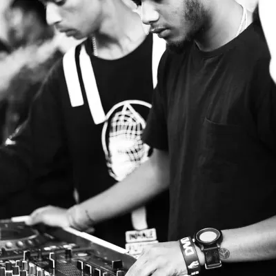 This artistic, black and white shot shows the intense focus required for mixing. Every transition and beat match is a deliberate choice to shape the audience's experience.