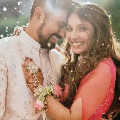 Bathed in golden light and showered with petals, this candid portrait captures the pure, unscripted joy between a couple. This is the kind of authentic emotion we love to photograph.