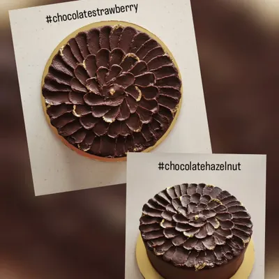 This shows how two cakes can look identical on the outside but have completely different flavors inside. One is a classic chocolate strawberry and the other is a rich chocolate hazelnut, both finished with the same textured ganache.