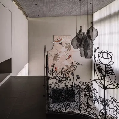 This custom metal railing tells a story of Ahmedabad's seasonal blooms. The intricate, laser-cut design features flowers and birds, transforming a safety feature into a delicate piece of line art that spans the corridors of the villa.