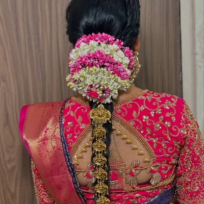 The quintessential South Indian bridal hairstyle. This close-up shows the intricate temple jewelry and the beautiful gajra bun, which are key elements of the look.