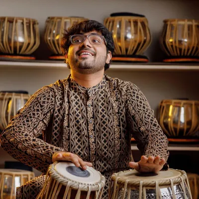 A favorite portrait of mine, surrounded by tablas in my practice space. The joy of being a musician is a constant in my life.