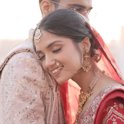 A tender moment between the couple. The bride's makeup is soft and romantic, designed to look beautiful up close and enhance the emotional connection in the photograph. This is a classic shot from a wedding day photoshoot.