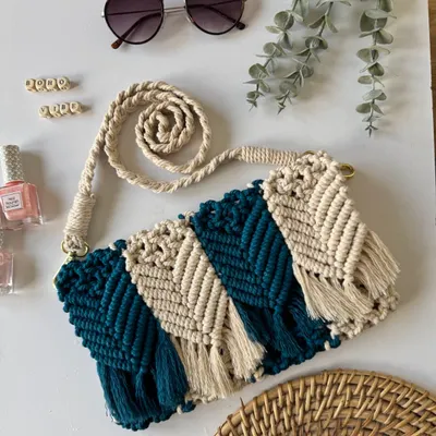 This custom macrame sling bag features a two-tone chevron pattern and a hand-knotted strap. It's made from soft but durable cotton cord, perfect for carrying your essentials with boho flair.