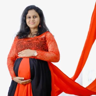 A beautiful mom-to-be looking radiant in my red and black maternity gown, complete with a flowing red trail for that extra touch of drama.