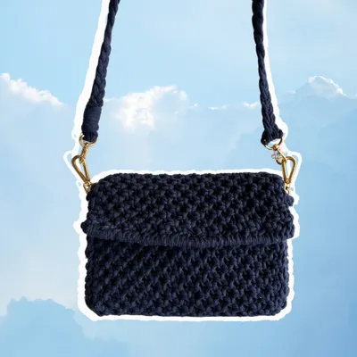 This is a classic macrame sling bag in a deep navy blue. It's a great everyday bag with a sturdy, knotted texture and a braided strap. We can customize the color and size to create the perfect bag for your aesthetic.