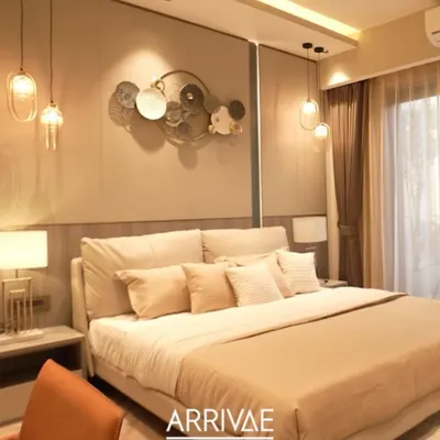 This master bedroom is the epitome of quiet luxury, with a plush, oversized headboard, soft ambient lighting from pendant lamps, and a soothing monochromatic beige color scheme.