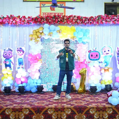 Posing on stage before hosting a fun-filled first birthday party. The Cocomelon theme was a big hit with the kids.