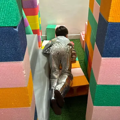 An astronaut exploring a colorful foam block canyon. Our play area encourages kids to build their own worlds and go on amazing adventures.