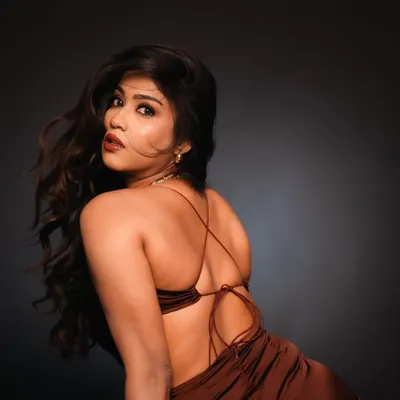 A powerful studio portrait using dramatic side lighting to highlight the model's features and the texture of her hair. The focus on the backless design of the dress adds a touch of allure and sophistication.