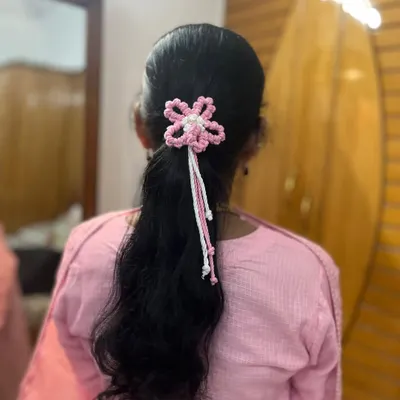 A beautiful pink and white macrame flower hair tie, perfectly adorning a simple ponytail. It adds such a delicate and pretty touch.