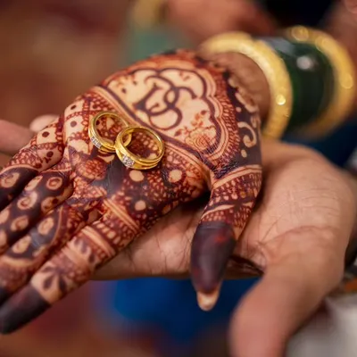A promise held in hand. This close-up of the engagement rings on the bride's intricate mehendi is a story in itself.