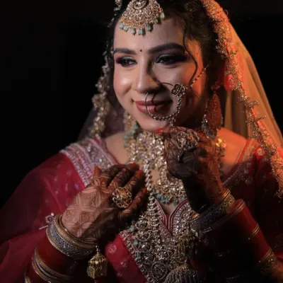 A close-up of a bride's stunning look, featuring a multi-layered kundan necklace, maang tikka, and nath. All this beautiful jewellery is available to rent along with the lehenga.