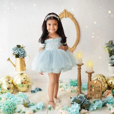 A beautiful princess in a world of blue and gold. This elegant studio portrait showcases a classic theme with a touch of sparkle and magic.