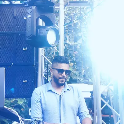 A cool, stylized shot of me at an outdoor event. The bright lighting and professional sound equipment in the background capture the scale of the events I play.