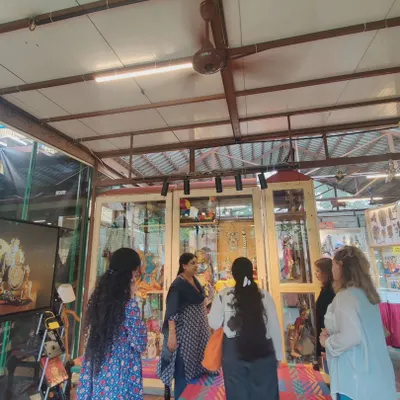 Guiding a group of students through the museum. Here, we are looking at our display cases, where I explain the different types of puppets and the stories they tell, making it an engaging educational experience.