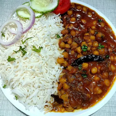 A plate of my classic Chole Chawal, a favorite for any community feast. I serve it with fluffy basmati rice and a fresh salad, making it a complete and satisfying meal for your guests.