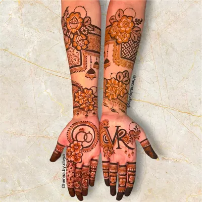 A perfect design for an engagement ceremony. This piece features the couple's initials 'VR', intertwined rings, and other celebratory motifs like jhumkas.