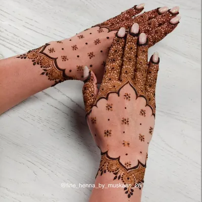 A beautiful example of a minimalist design. The scalloped border and scattered floral 'booti' create a chic and elegant look on the back of the hand.
