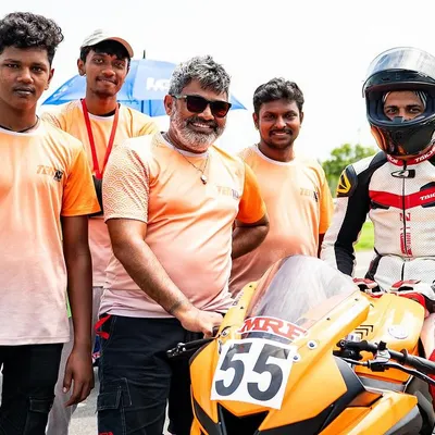 This is my team. I stand with my crew and a student racer after a successful session. I believe in a strong support system to help every rider grow, from the mechanics to the coaching staff.