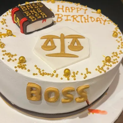 A birthday cake for the "Boss," decorated with legal symbols like the scales of justice and a law book.
