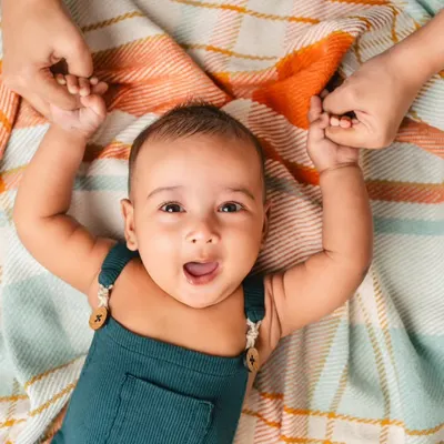 Look at that expressive face! This is from a 3-month-old's infant session, capturing that precious stage of wiggles and giggles on a soft blanket.