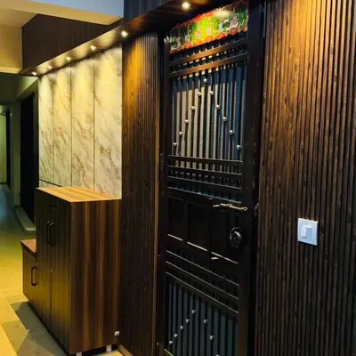 This is an entrance I designed for a client in Noida, featuring warm wood-toned fluted panels and focused lighting to create a welcoming ambiance. A sleek, built-in shoe rack keeps the entryway organized, which is essential for good Vastu.