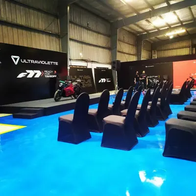 The stage and seating arrangement for the Ultraviolette automotive launch event. The industrial warehouse setting was transformed with strategic lighting and a custom stage to create a modern, edgy atmosphere for the brand reveal.