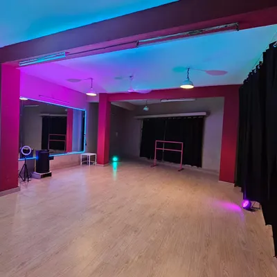 A glimpse of the studio's potential with dual-tone pink and blue lighting. This setup is perfect for creating dynamic, eye-catching content and highlights the ring light and ballet barre available for your use.