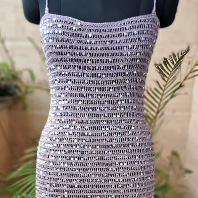 This handmade crochet cocktail dress, intricately woven with shimmering sequins, represents our vision of blending timeless craft with contemporary glamour. It's a statement piece designed to make you shine at any special occasion.