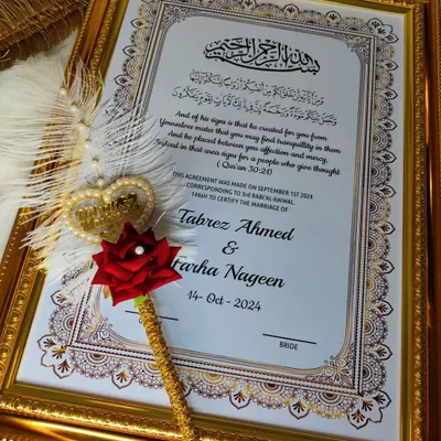 A beautifully framed Nikah certificate, ready to be displayed in your home. The gold frame complements the intricate border design, and the custom feather pen rests beside it.