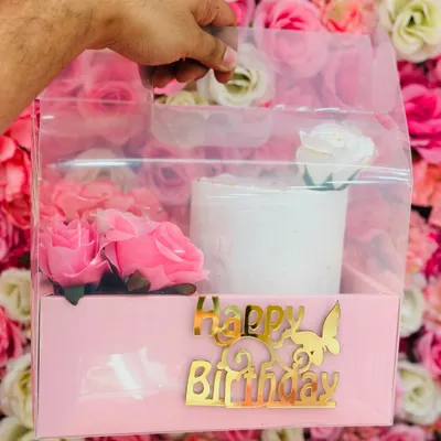 The complete birthday solution. This hamper includes a half-kg tall cake with an elegant white finish, a bunch of pink roses, and a 'Happy Birthday' topper, presented in a clear-view box.