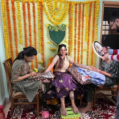 A behind-the-scenes look at a bridal mehndi session at the client's home. You can see the festive setup and my team and I focused on adorning the bride for her big day. We bring the complete professional experience to you.