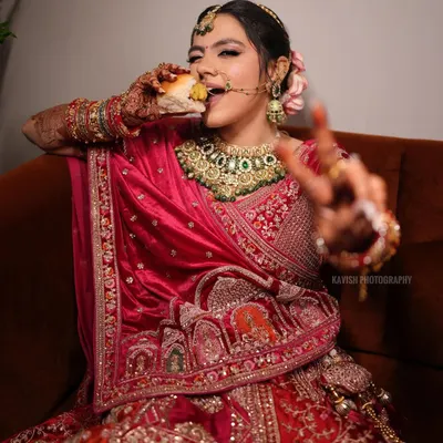 A fun and real moment of the bride enjoying a snack in her full wedding attire. It's these candid, unscripted shots that make memories.