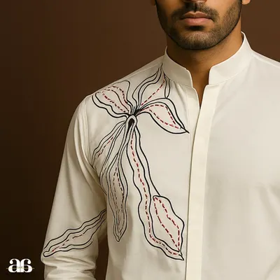 A closer look at our off-white embroidered shirt. The abstract floral design is rendered in black and red thread, creating a piece of wearable art that is perfect for making a modern style statement.