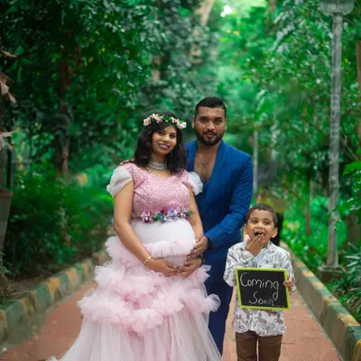 A complete family portrait for a maternity announcement. We provided the pink ruffle gown for mom, a stylish blue suit for dad, and a cute outfit for the big brother-to-be.