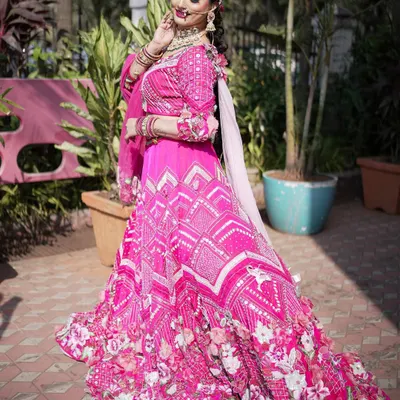 A stunning bride in a vibrant pink lehenga, perfect for a grand wedding. The makeup is glamorous yet fresh, with a focus on radiant skin and beautifully defined eyes.