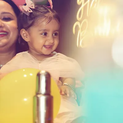 A bright and happy portrait of the birthday girl. The soft lighting and her natural smile make this a perfect candid shot, capturing the pure joy of a child's celebration.