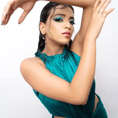 A modern fashion portrait with a wet hair look and bold teal eyeshadow. This style is perfect for a model's portfolio, showcasing a contemporary and edgy side.