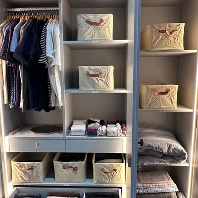 This beautifully lit wardrobe shows a perfect balance of hanging space for shirts and folded items in drawers and matching bins. Creating this functional harmony is key to a closet that works for you, not against you.