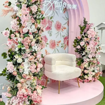 A dreamy "Bride to Be" setup perfect for a bridal shower or mehendi. The pastel pink arch, cascading florals, and a chic statement chair create a romantic and highly Instagram-worthy photo corner.