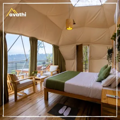 The interior of a Geodesic Dome at Hypnotic Stays, Wayanad. The large panoramic window lets you wake up to incredible views of the tea estates right from your bed.