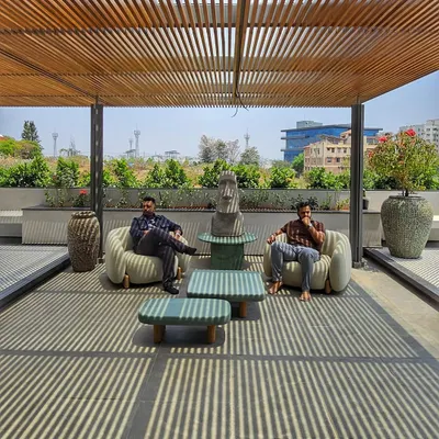 On this rooftop terrace, a wooden pergola creates a beautiful play of linear shadows, transforming the space into a dynamic canvas of light.